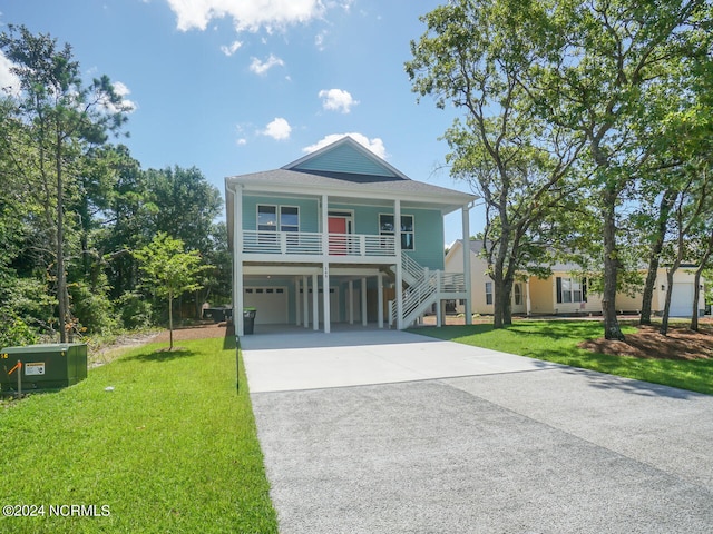 beach home featuring aphalt driveway, a porch, stairway, a front yard, and a carport