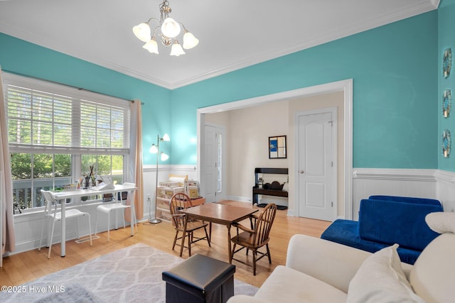 dining room with a wainscoted wall, an inviting chandelier, wood finished floors, and crown molding