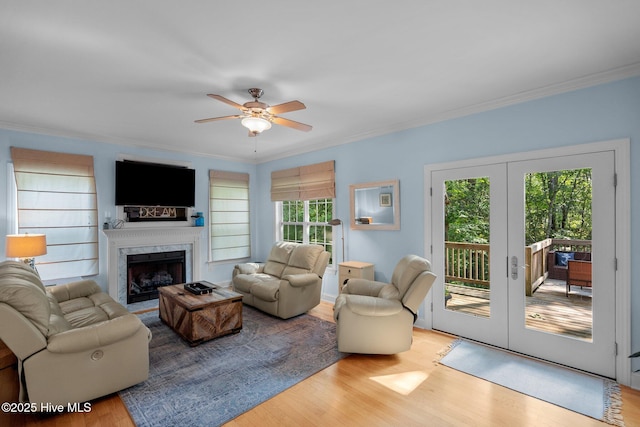 living area with a premium fireplace, crown molding, and wood finished floors