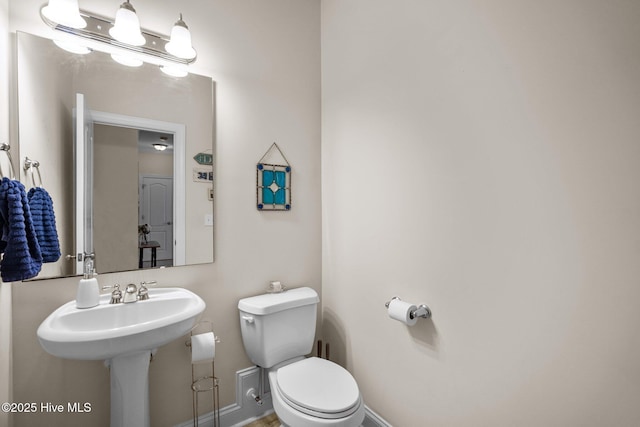 bathroom featuring toilet and baseboards