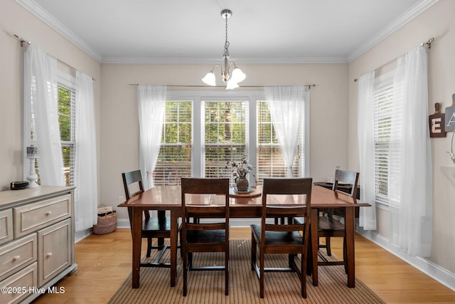 dining area featuring light wood-type flooring, an inviting chandelier, and ornamental molding