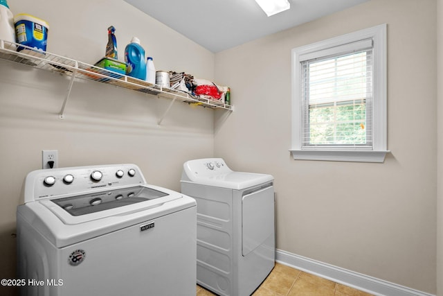 laundry area featuring laundry area, light tile patterned floors, baseboards, and washing machine and clothes dryer