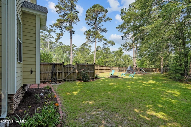 view of yard featuring a playground, a gate, and a fenced backyard