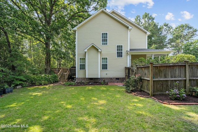 rear view of property featuring stairway, a lawn, fence, and crawl space