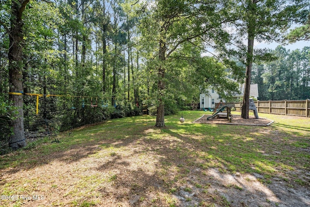 view of yard featuring a playground and fence