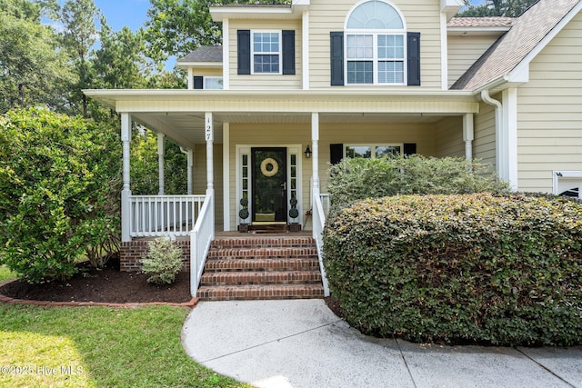 property entrance with a porch and a shingled roof