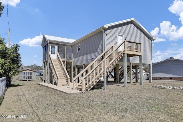 rear view of property featuring stairs and a sunroom