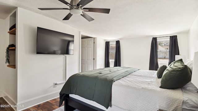 bedroom with baseboards, a textured ceiling, dark wood-style floors, and a ceiling fan