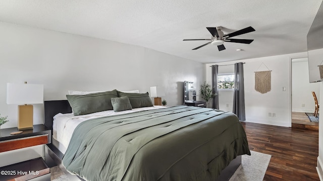 bedroom with ceiling fan, baseboards, a textured ceiling, and wood finished floors