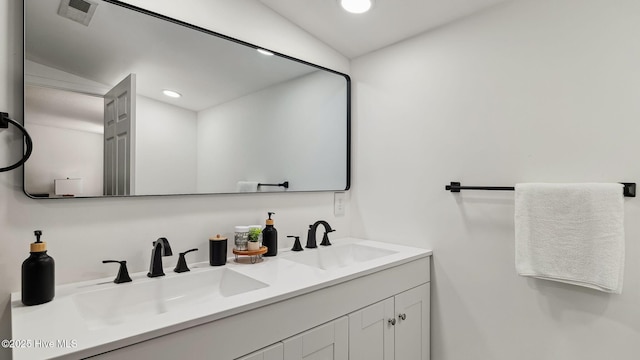 bathroom featuring a sink, visible vents, recessed lighting, and double vanity