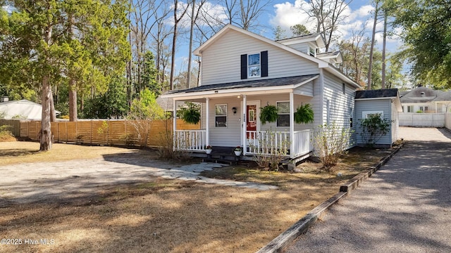 view of front of home with covered porch and fence