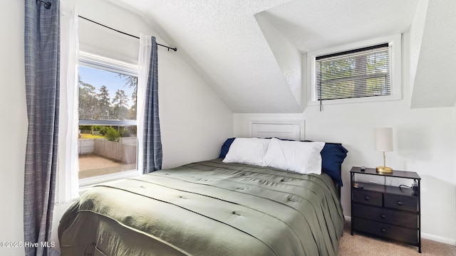 bedroom featuring vaulted ceiling, multiple windows, carpet, and a textured ceiling