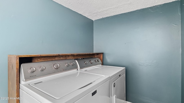 washroom featuring washer and dryer, a textured ceiling, and laundry area