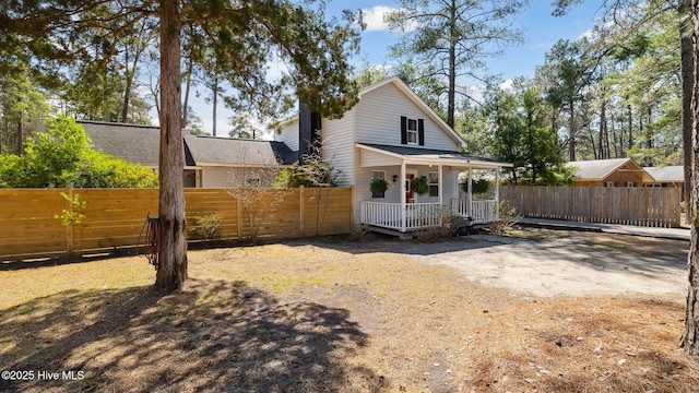 back of house with a porch and fence