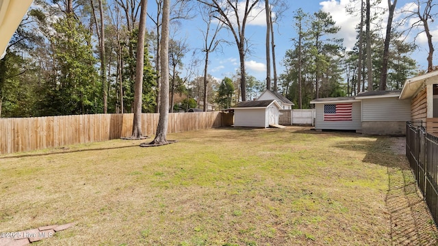 view of yard featuring an outbuilding, a fenced backyard, and a shed