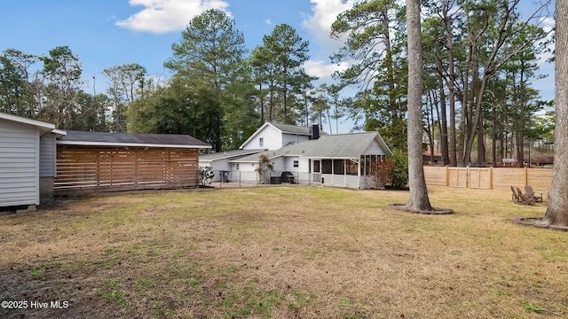 view of yard featuring a sunroom and fence