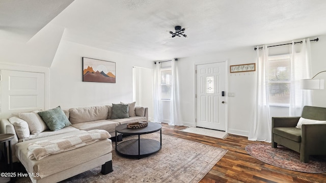 living area with wood finished floors, baseboards, a wealth of natural light, and a textured ceiling