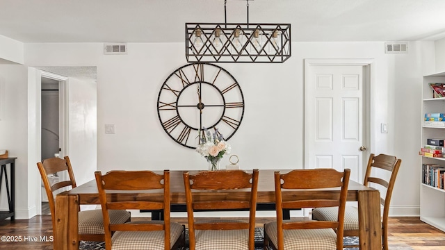 dining room with visible vents, baseboards, and wood finished floors