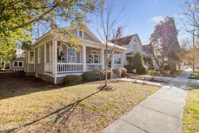 bungalow with a porch, a front yard, and crawl space