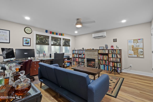 office featuring a wall mounted air conditioner, light wood-style flooring, ceiling fan, and recessed lighting