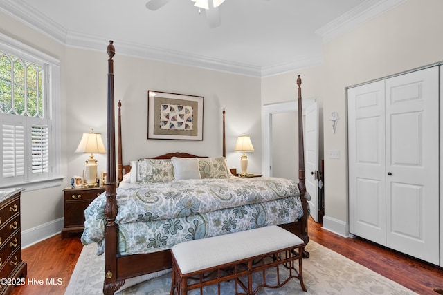 bedroom featuring crown molding, wood finished floors, a closet, and baseboards