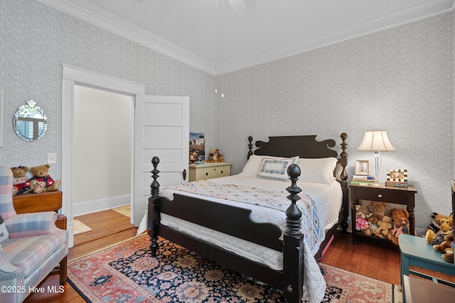 bedroom with baseboards, wood finished floors, ornamental molding, and wallpapered walls