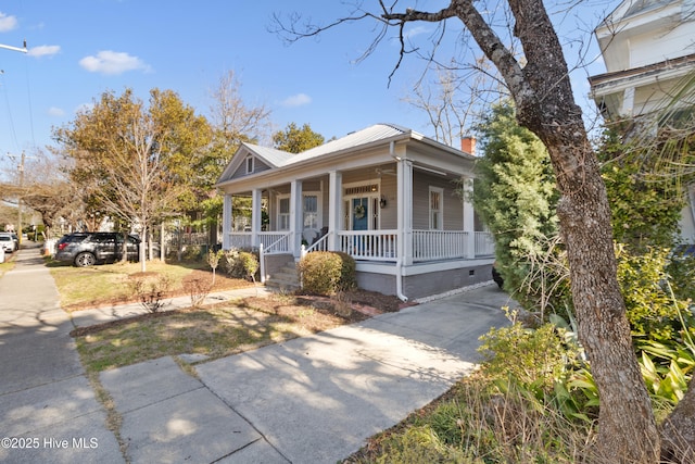 view of front of home featuring concrete driveway, metal roof, covered porch, and crawl space