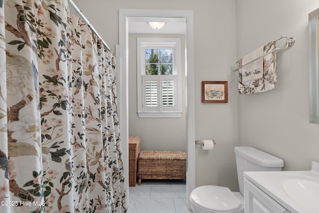 full bath with a shower with curtain, toilet, marble finish floor, and vanity