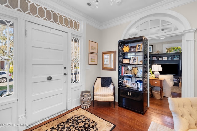 entryway featuring visible vents, plenty of natural light, crown molding, and wood finished floors