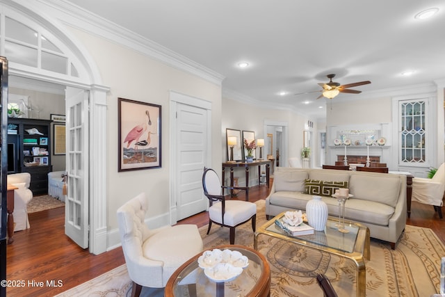 living room featuring wood finished floors, baseboards, recessed lighting, ceiling fan, and crown molding