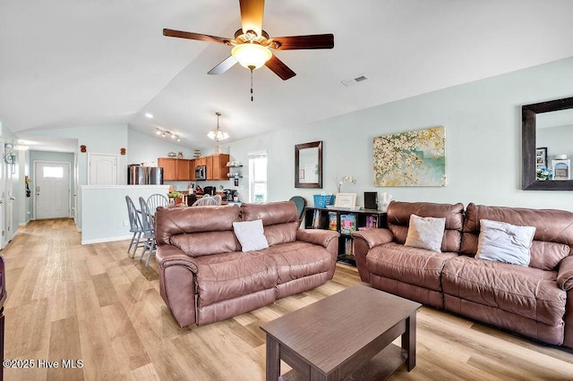 living room featuring visible vents, a ceiling fan, light wood-style floors, and lofted ceiling