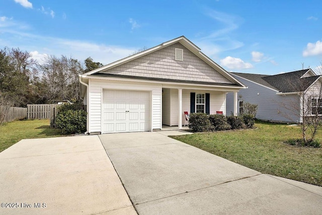 view of front of house featuring a front yard, fence, a garage, and driveway