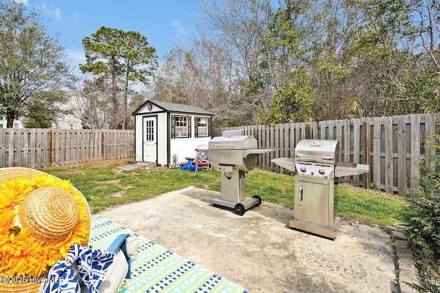 view of patio featuring an outdoor structure, a fenced backyard, a shed, and grilling area