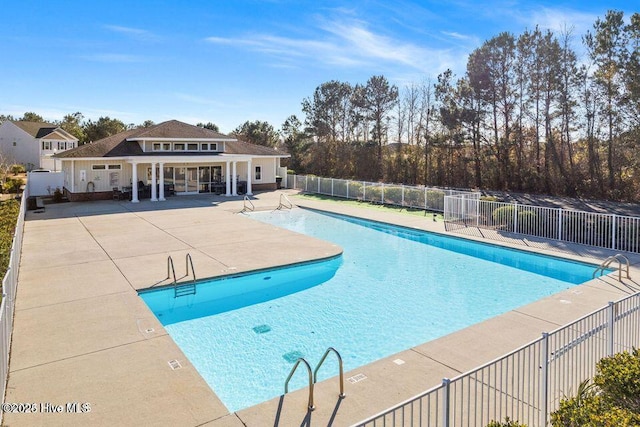 community pool featuring a patio and fence