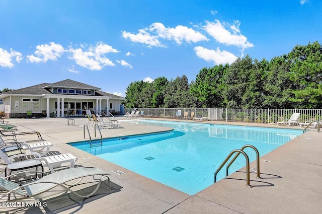 community pool featuring a patio and fence
