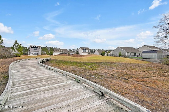 view of dock featuring fence, a residential view, and a lawn