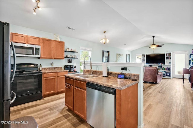 kitchen featuring lofted ceiling, light wood-style flooring, a sink, appliances with stainless steel finishes, and open floor plan