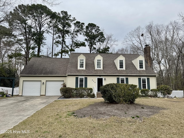 cape cod house with concrete driveway, an attached garage, fence, and a chimney