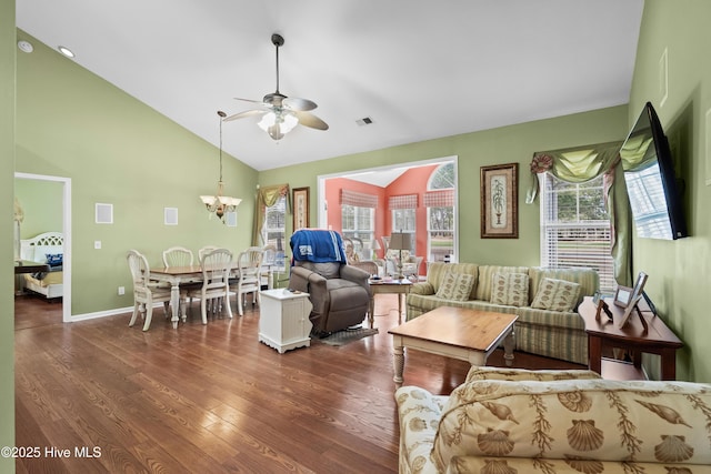 living area with visible vents, dark wood-type flooring, ceiling fan with notable chandelier, baseboards, and vaulted ceiling