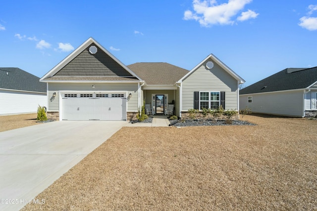 view of front of house featuring an attached garage, stone siding, and driveway