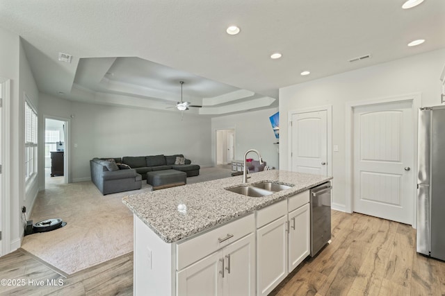 kitchen featuring visible vents, stainless steel appliances, a raised ceiling, and a sink