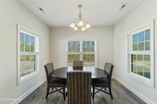 dining space with dark wood finished floors, baseboards, visible vents, and a chandelier