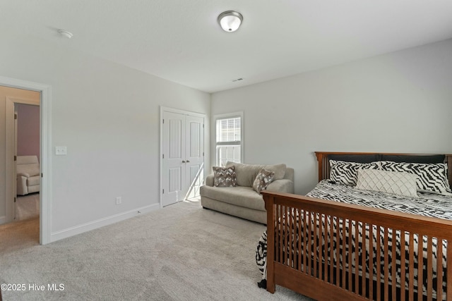 carpeted bedroom with a closet and baseboards