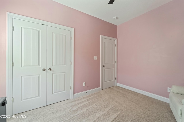 unfurnished bedroom featuring a closet, ceiling fan, baseboards, and carpet floors