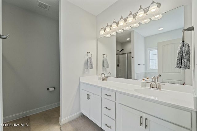 full bath featuring tile patterned floors, visible vents, a sink, a shower stall, and baseboards