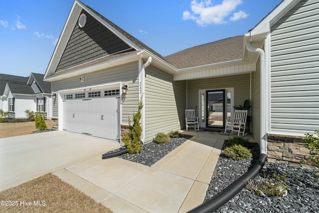 view of side of property featuring a garage, roof with shingles, and concrete driveway