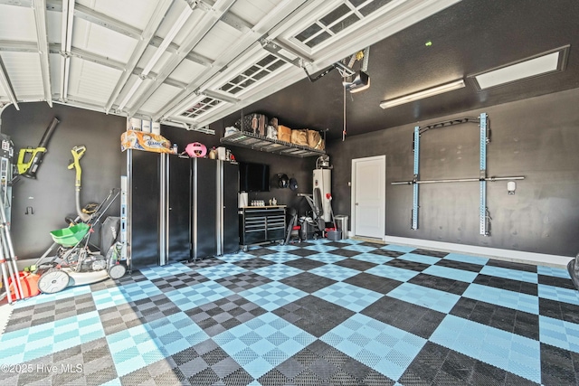 garage with a garage door opener, water heater, and baseboards