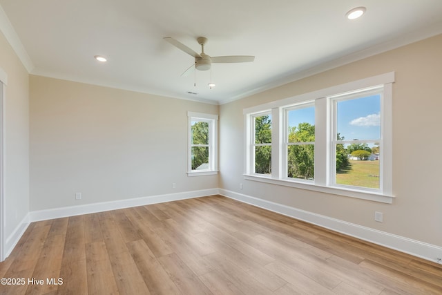 spare room featuring ceiling fan, baseboards, crown molding, and light wood-style floors