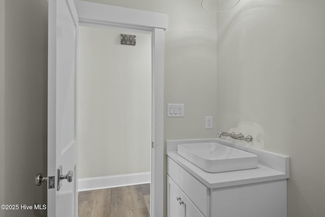 bathroom featuring vanity, wood finished floors, and baseboards