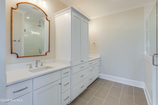 bathroom featuring baseboards, vanity, tile patterned flooring, and a shower stall